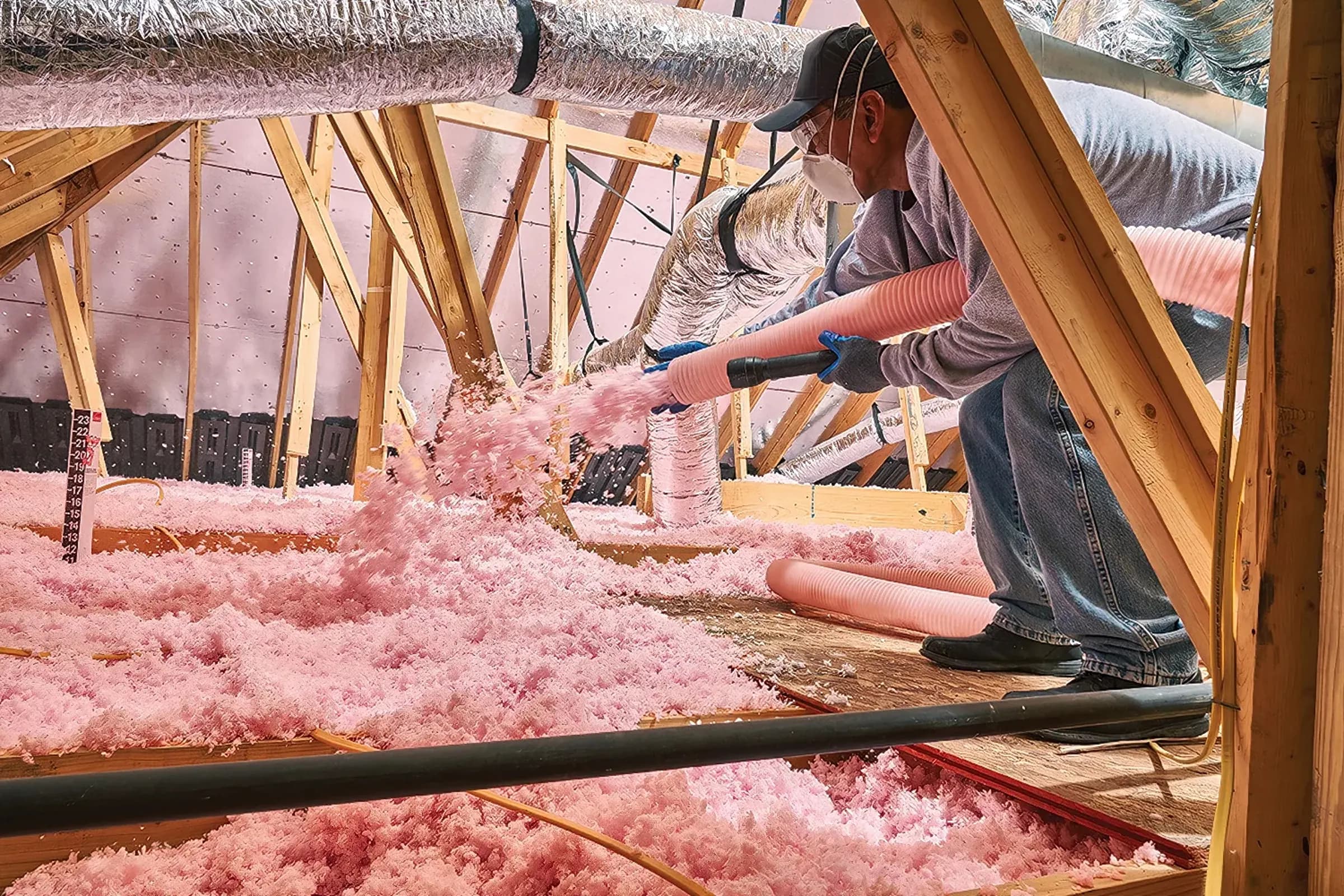 Insulation technician working in a residential attic project.
