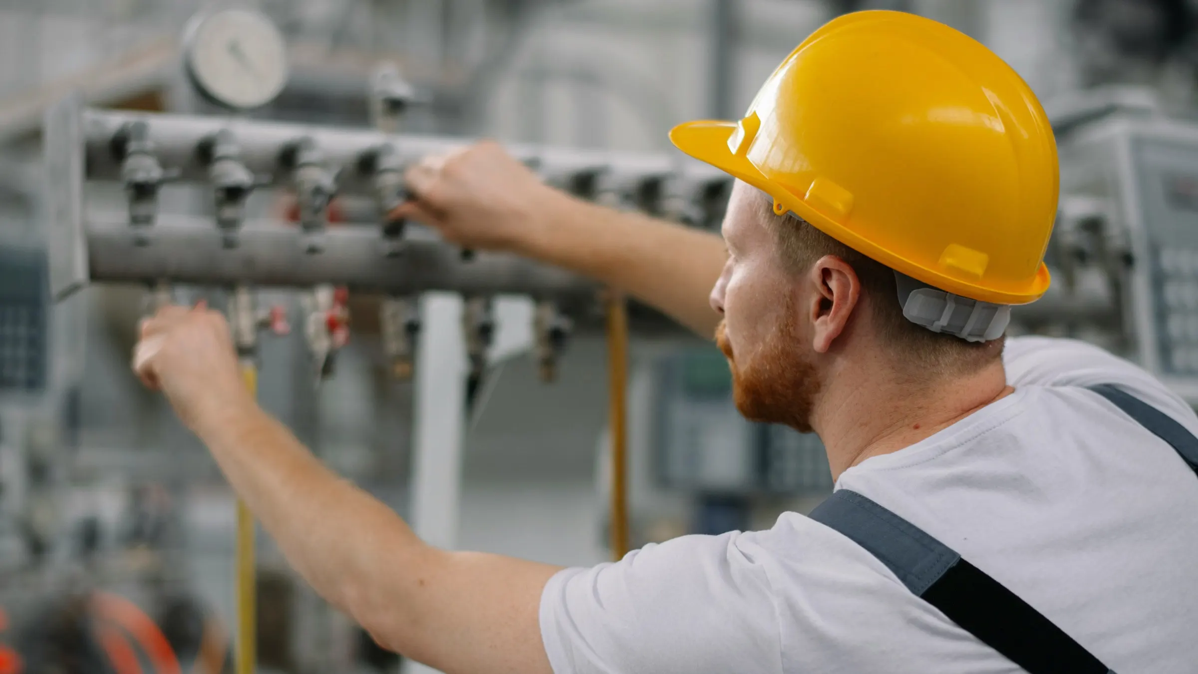 Technician adjusting industrial piping.
