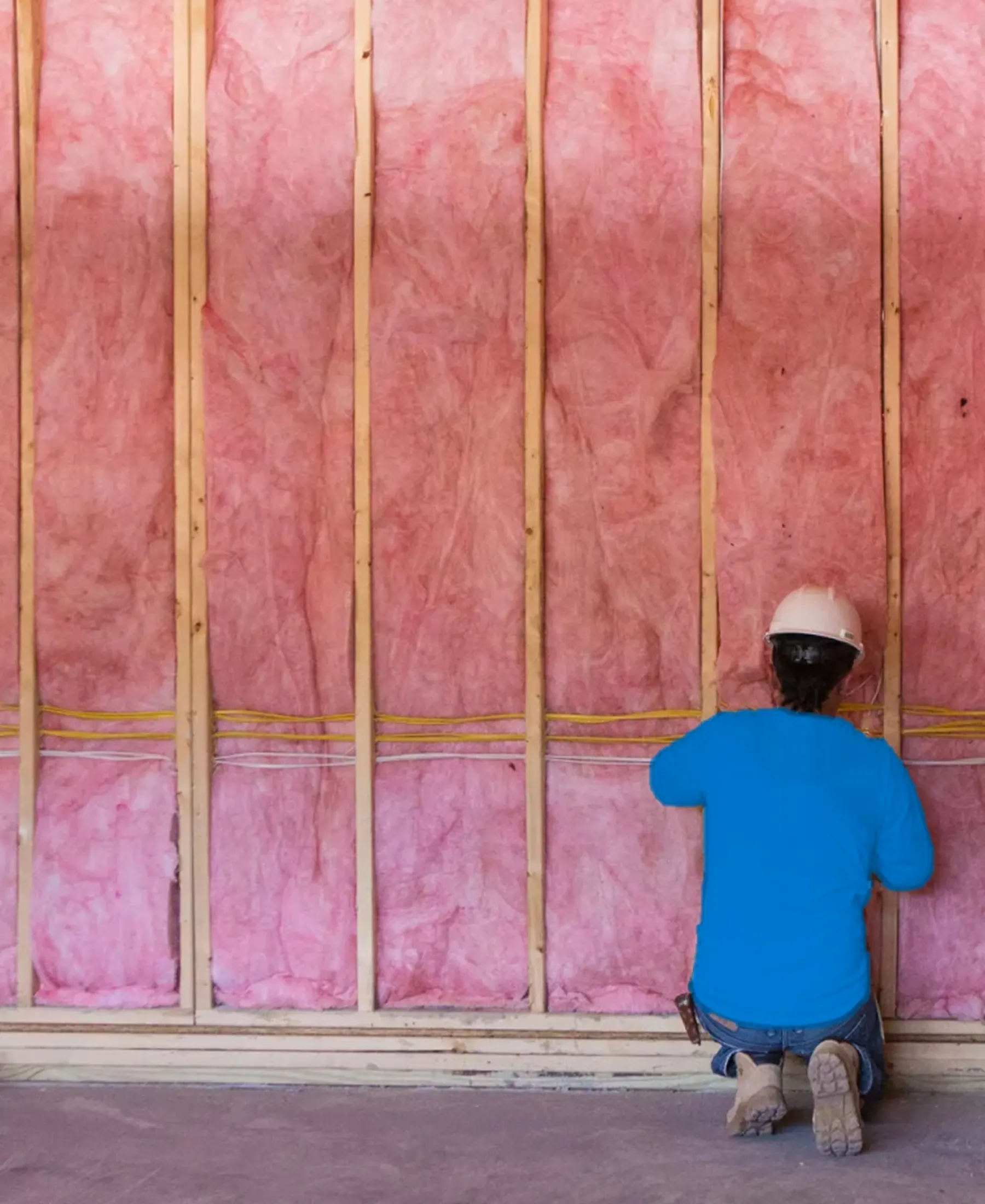 Insulation Technician installing batting in walls on a residential construction site