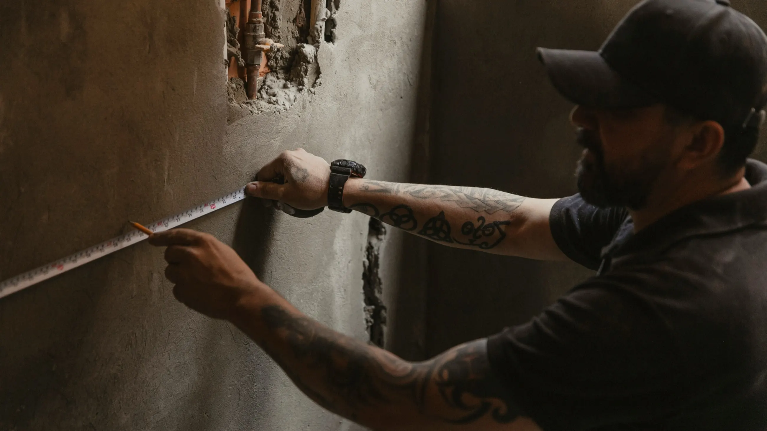 Worker measuring wall surface during a jobsite walkthrough