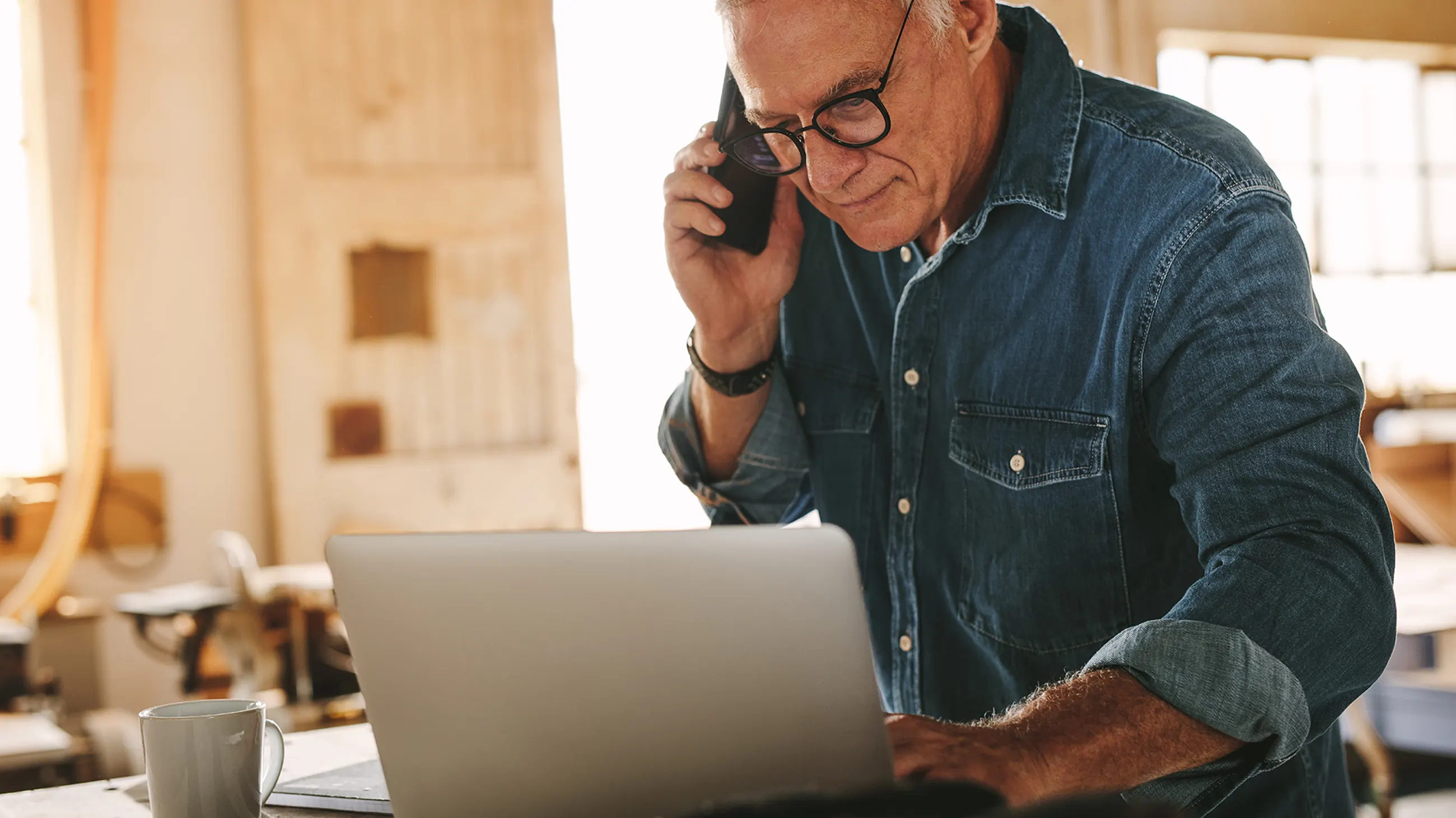 Home services business owner working on laptop computer in his shop