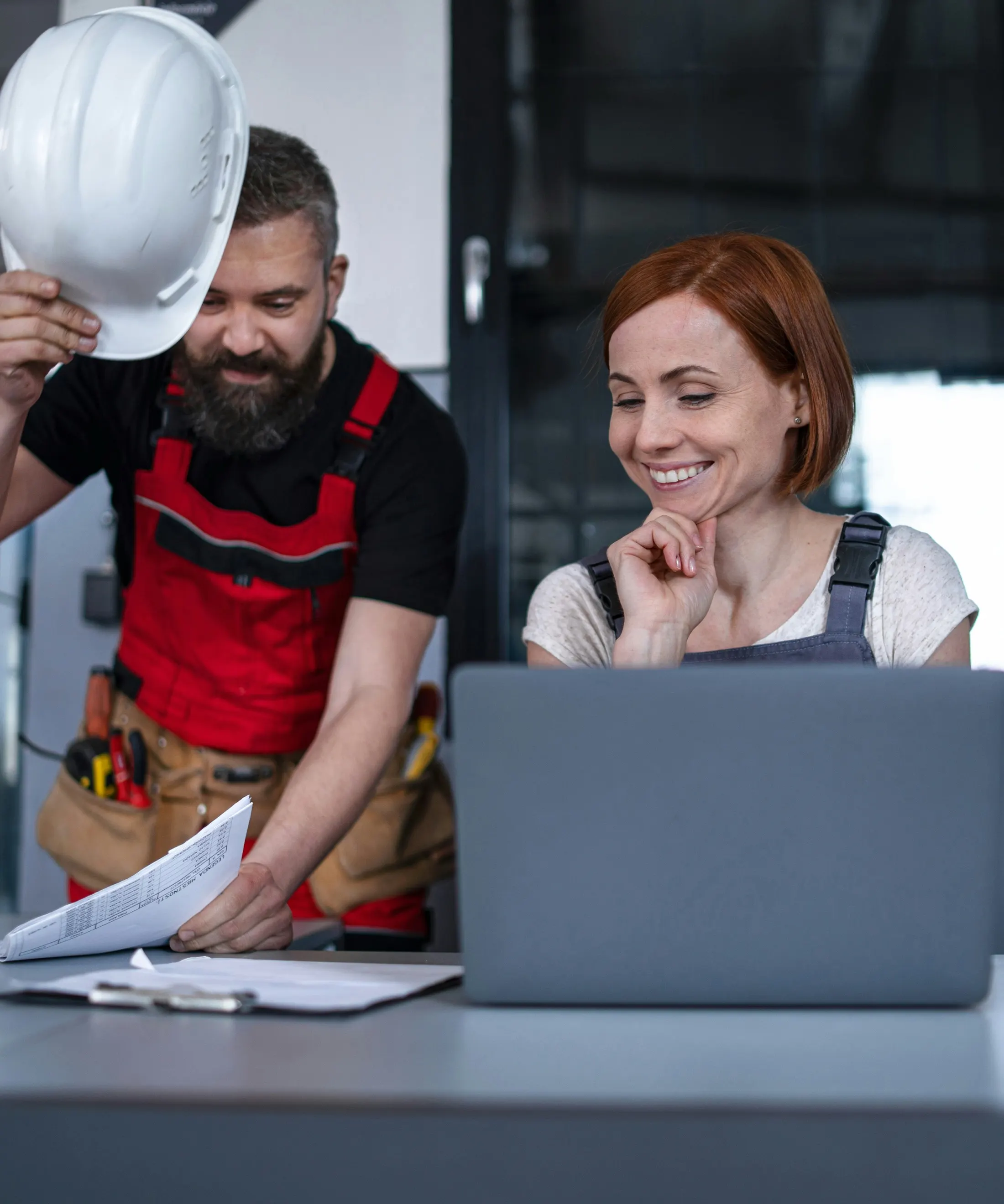 Contractor and operator reviewing a laptop on site
